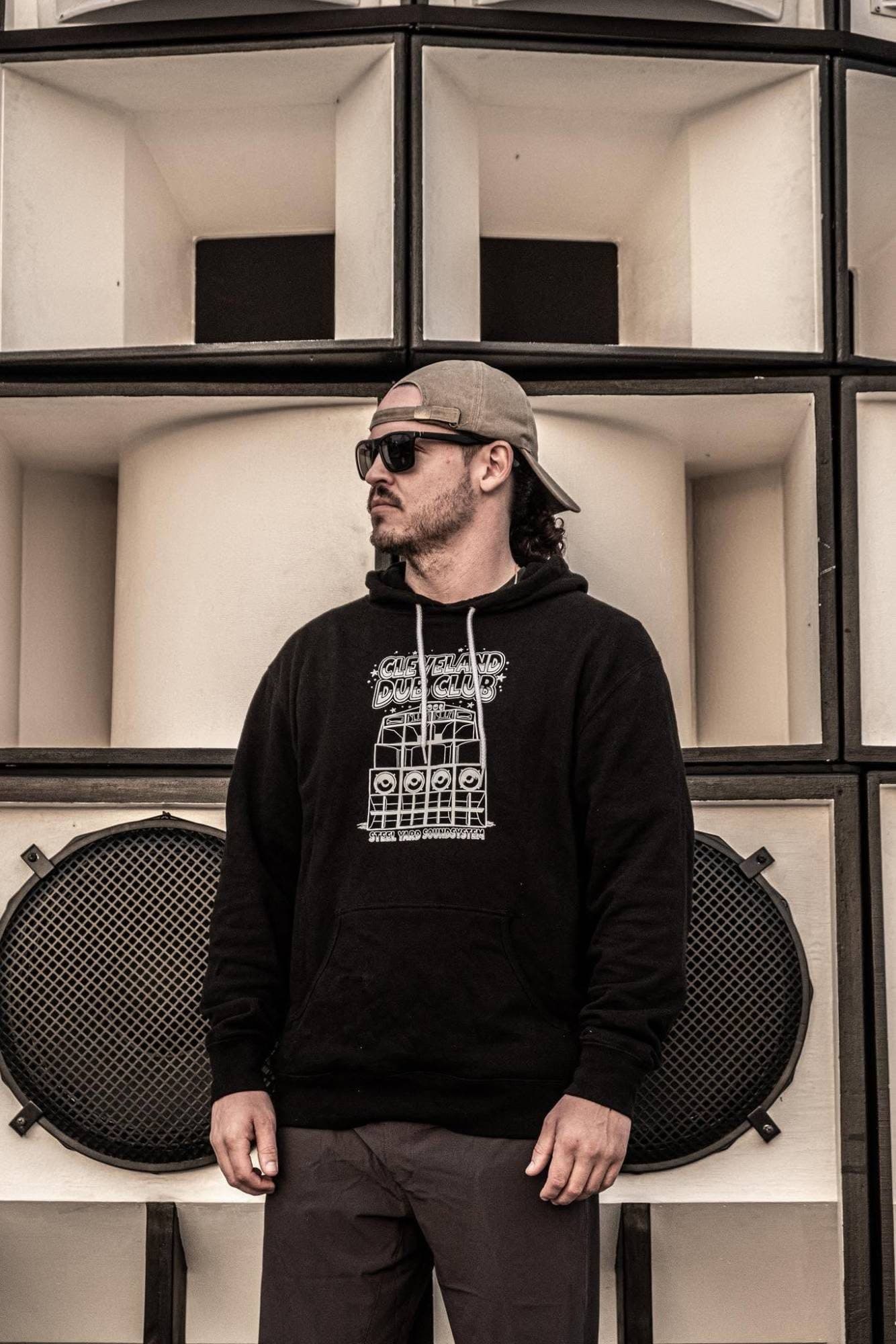 DJ Maxafari standing in front of a sound system speaker stack